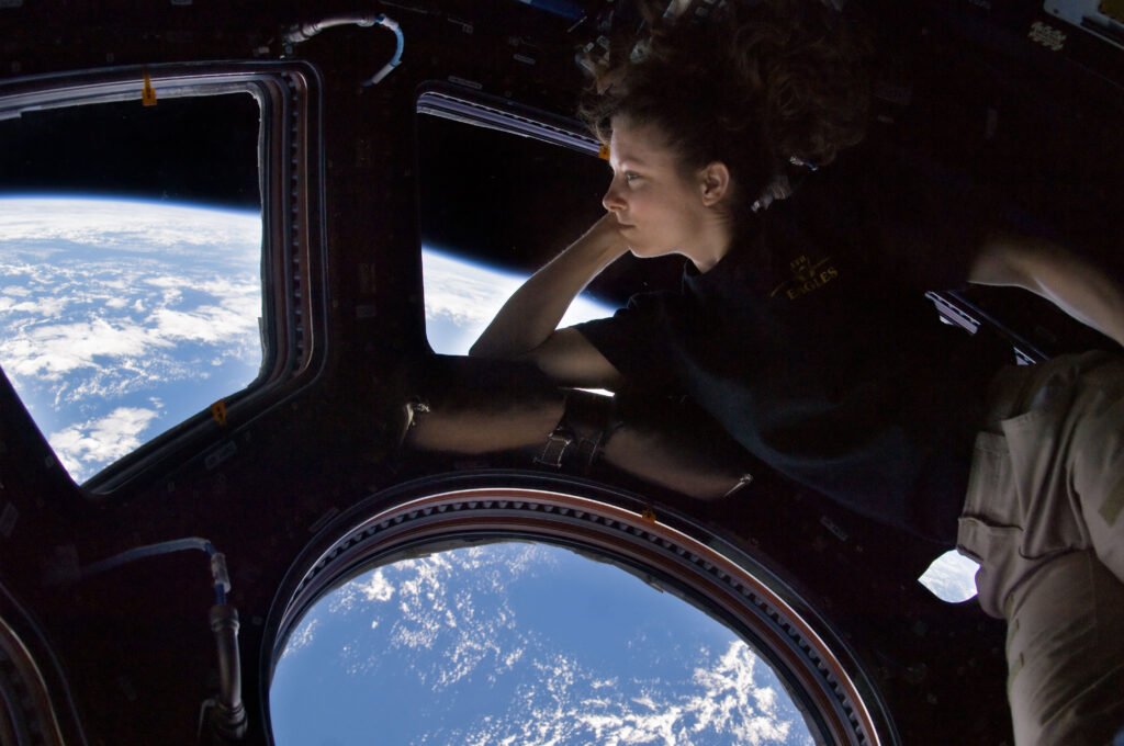 Astronaut Tracy Caldwell Dyson looks out through the windows of the International Space Station's Cupola at the Earth below.
